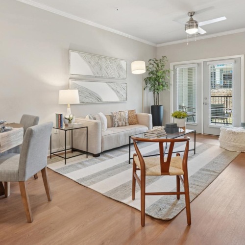 At The One at Columbia, a modern living room in our new apartments in Columbia, SC showcases a glass coffee table and abstract wall art.
