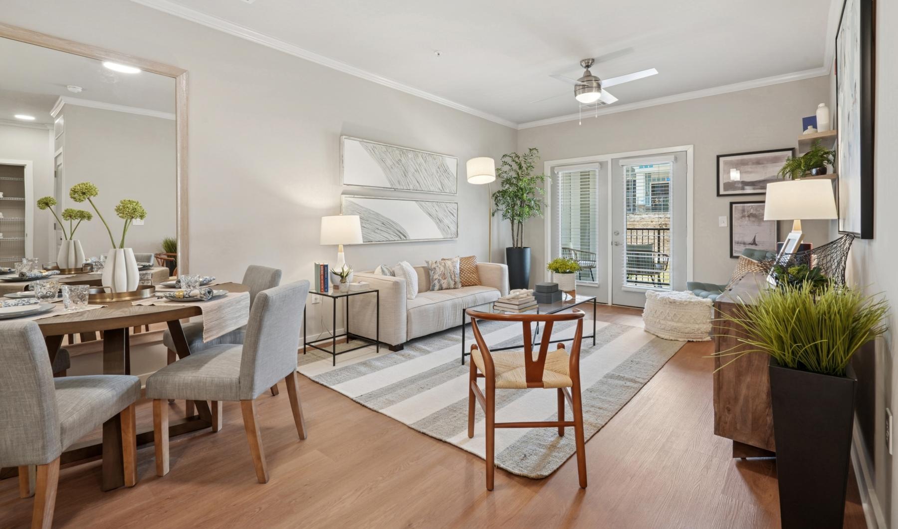 A well-lit, modern living room in our Columbia apartments at The One at Columbia flows into a dining area and kitchen.