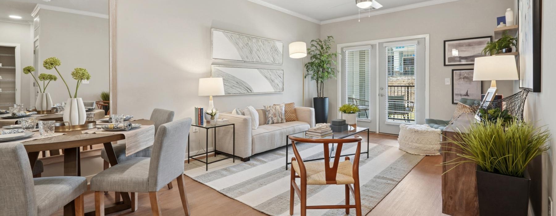 A well-lit, modern living room in our Columbia apartments at The One at Columbia flows into a dining area and kitchen.